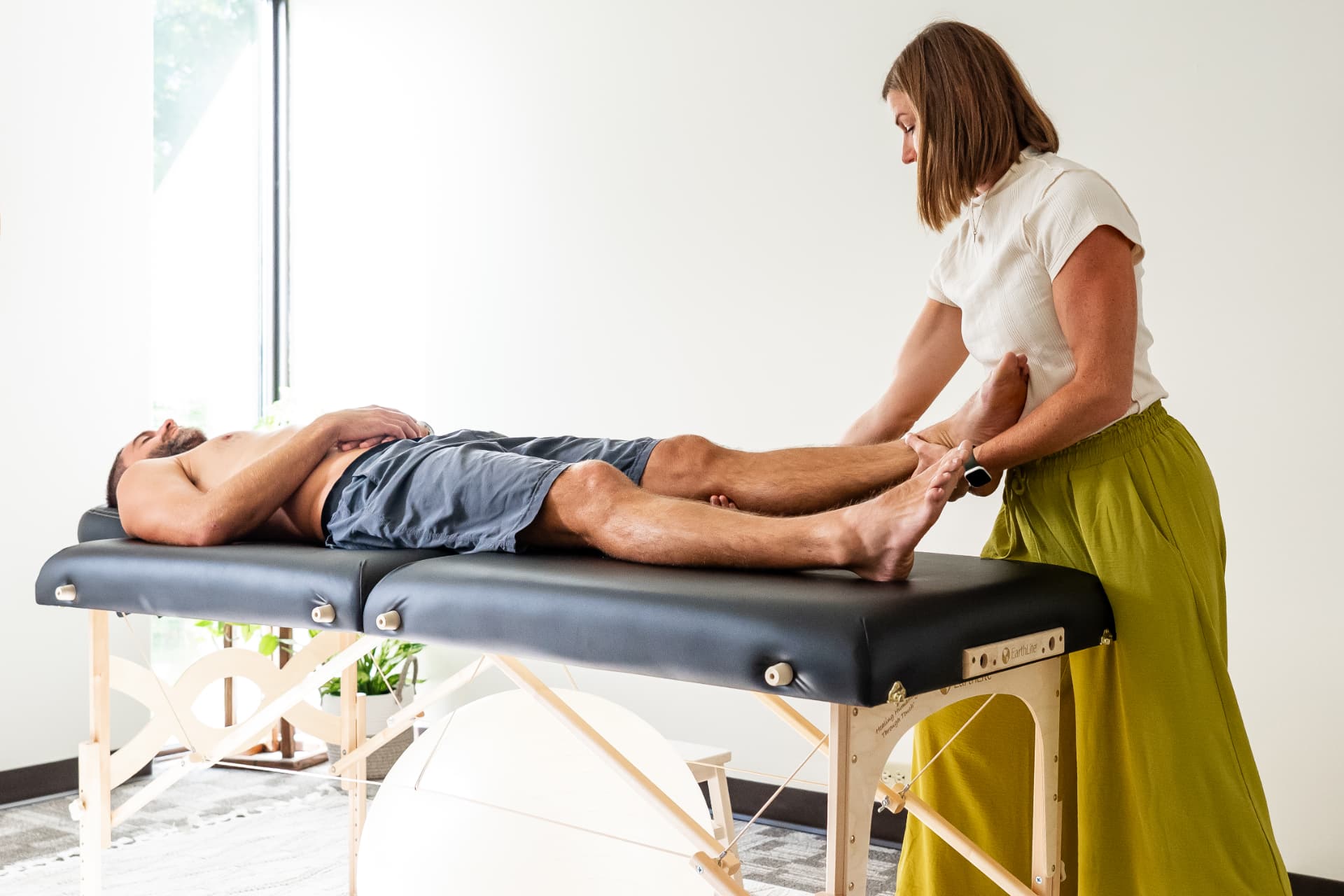 Sarah providing a gentle Myofascial Release leg pull during a treatment session.